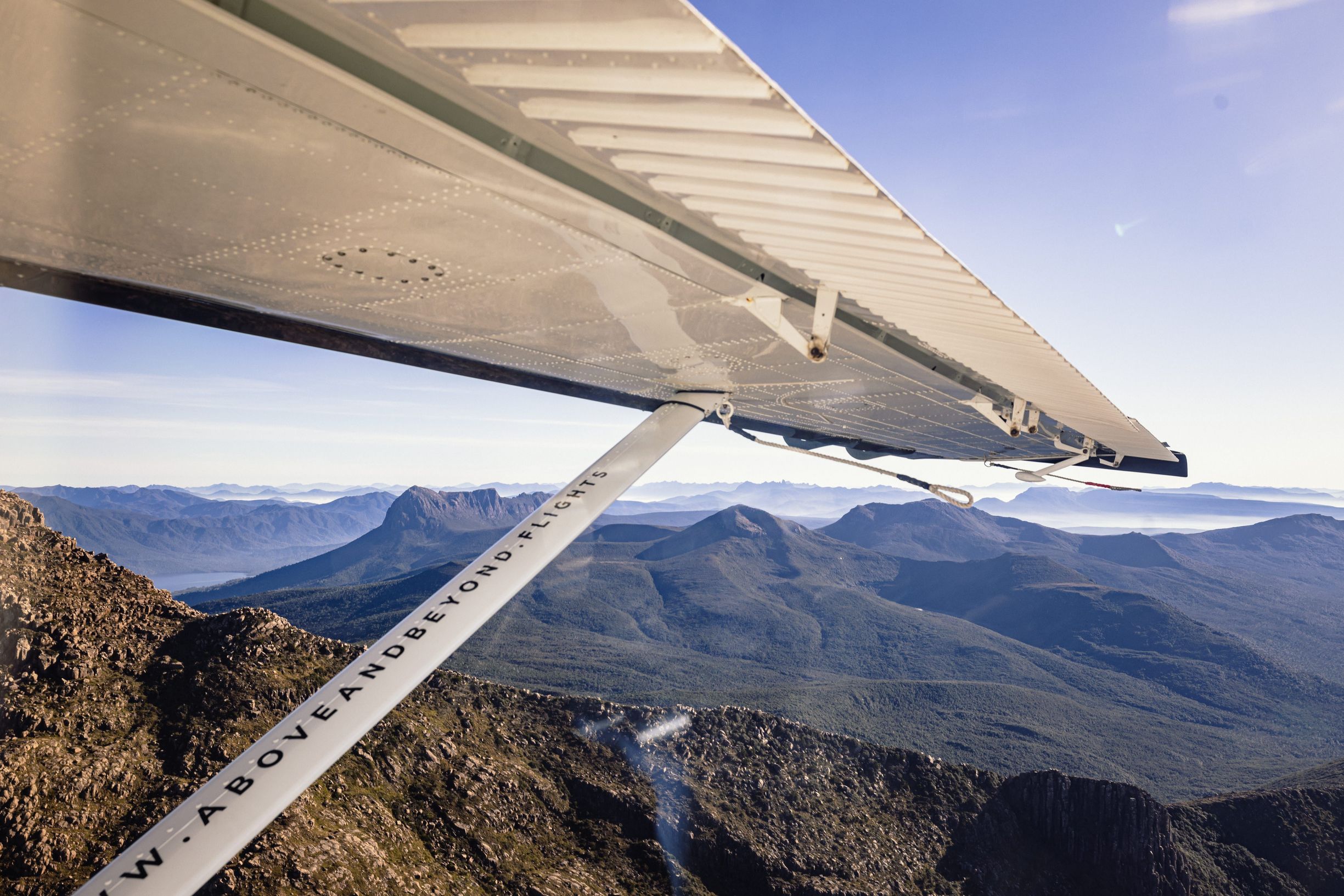 View of rugged mountain wilderness from an Above and Beyond Flights seaplane wing