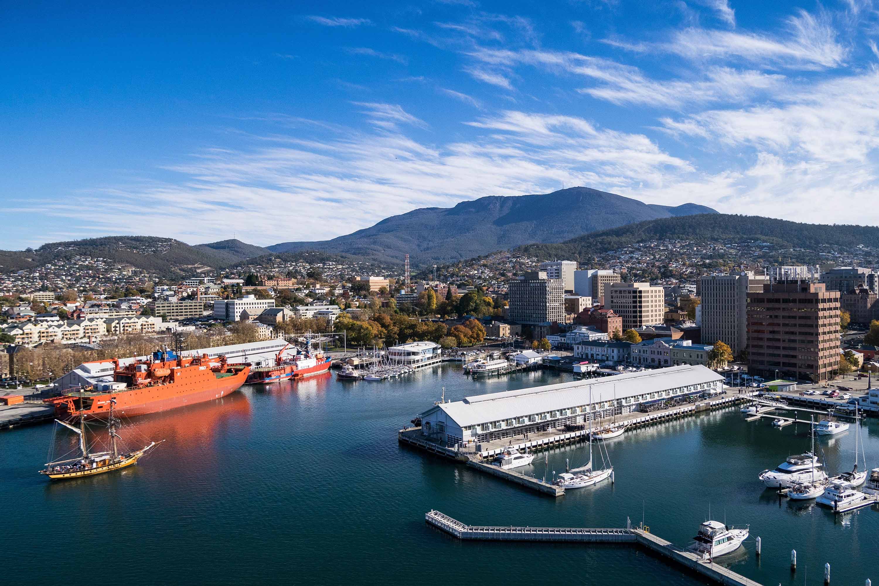 Aerial view of Hobart waterfront with boats, piers and the city below kunanyi / Mount Wellington